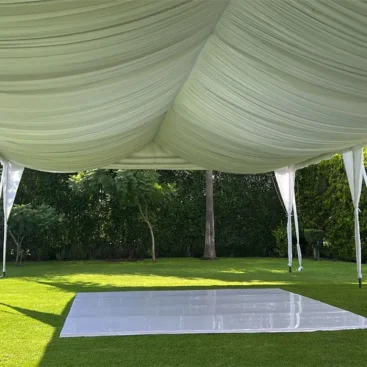 Interior de carpa blanca con plafón plisado y pista de charol