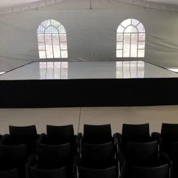 Templete de charol blanco con sillas dentro de una carpa